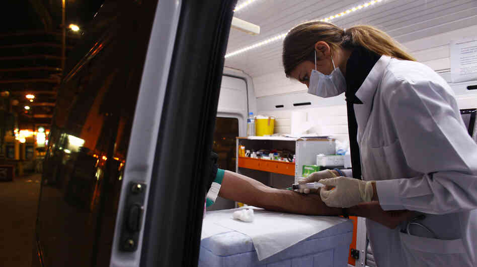 Nurse Maria Vatista draws blood from a Greek drug addict for an HIV test in a mobile testing van in Athens last year. HIV infection rates are rising, as Greece's financial crisis has led the government to cut health and social services, including a successful needle exchange program.