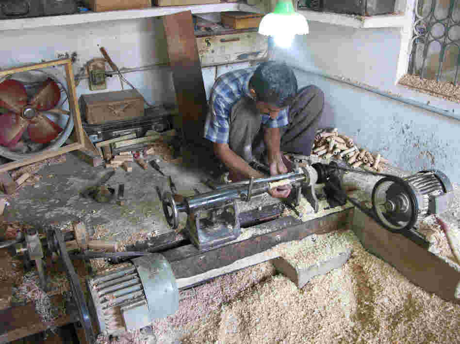 A lathe operator in the workshop of Halifax and Company turns out wood spindles that will be part of the pipes in toy bagpipes.