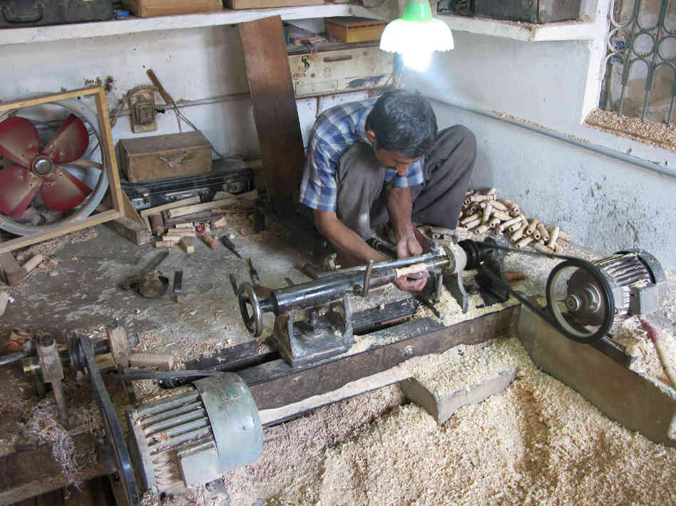 A lathe operator in the workshop of Halifax and Company turns out wood spindles that will be part of the pipes in toy bagpipes.