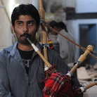 Ibrahim Ahmad, the son of the owner of the Imperial Bagpipe Manufacturing Co., tests a bagpipe at a factory in Sialkot, Pakistan. The Pakistani city is the largest producer of the instruments most commonly associated with Scotland.