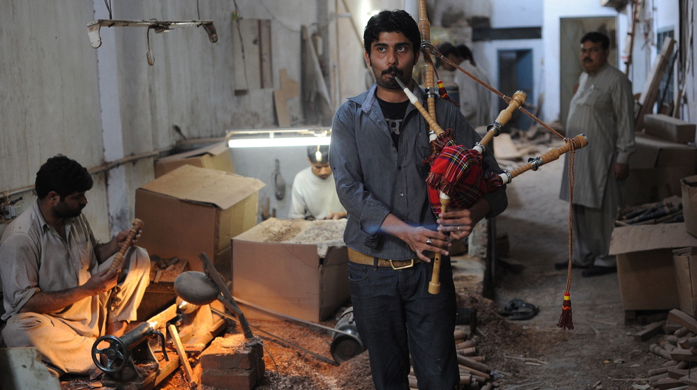 Ibrahim Ahmad, the son of the owner of the Imperial Bagpipe Manufacturing Co., tests a bagpipe at a factory in Sialkot, Pakistan. The Pakistani city is the largest producer of the instruments most commonly associated with Scotland.