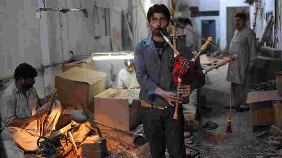 Ibrahim Ahmad, the son of the owner of the Imperial Bagpipe Manufacturing Co., tests a bagpipe at a factory in Sialkot, Pakistan. The Pakistani city is the largest producer of the instruments most commonly associated with Scotland.