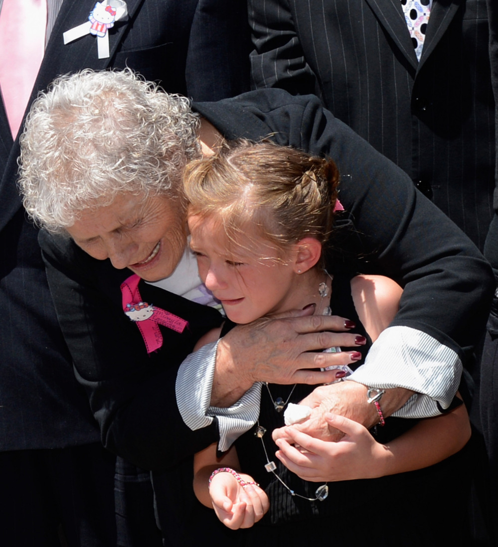 Grandma Marlene Kenobbe (L) comforts consoles Kailyn Vigil during Micayla Medek's funeral at the New Hope Baptist Church in Denver, Colorado.