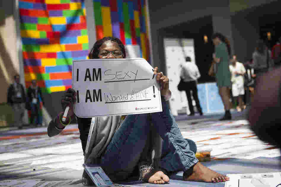Getting the word out about HIV was a major goal of the Global Village. Helena Nangombe from Namibia holds up a sign written by her friend during a session that aimed to promote communication about HIV.