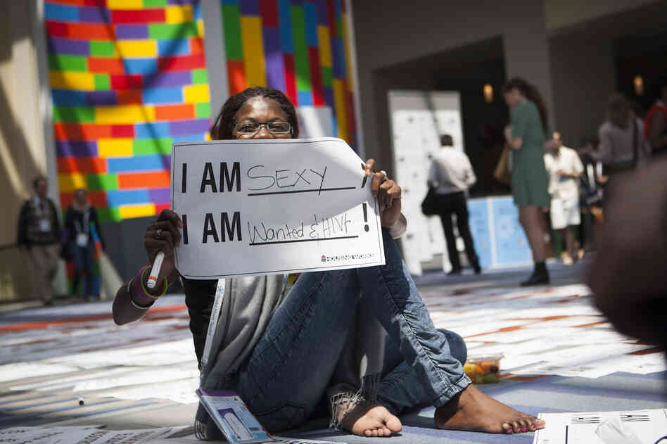 Getting the word out about HIV was a major goal of the Global Village. Helena Nangombe from Namibia holds up a sign written by her friend during a session that aimed to promote communication about HIV.