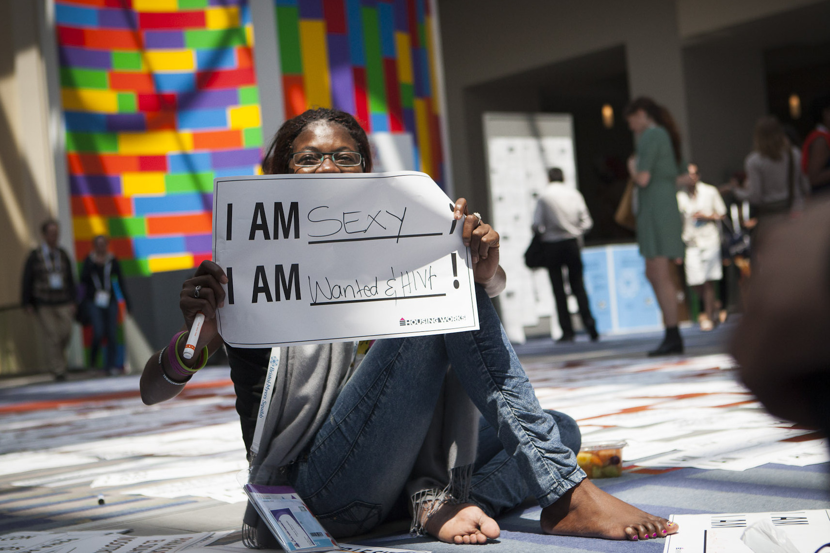 Getting the word out about HIV was a major goal of the Global Village. Helena Nangombe from Namibia holds up a sign written by her friend during a session that aimed to promote communication about HIV.
