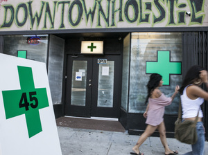 Pedestrians walk past a medical marijuana dispensary in the Echo Park area of Los Angeles Tuesday. The City Council voted that day to ban marijuana shops outright. Pedestrians walk past a medical marijuana dispensary in the Echo Park area of Los Angeles Tuesday. The City Council voted that day to ban marijuana shops outright.