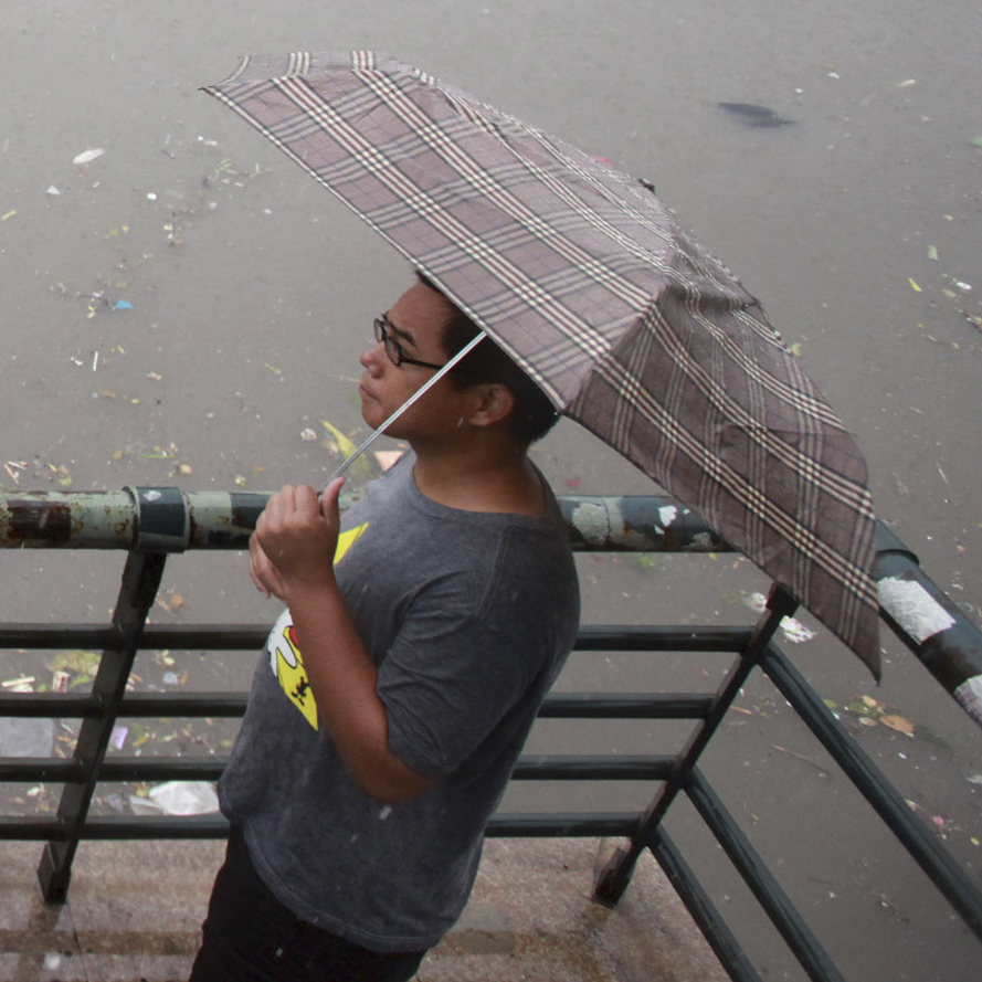 Residents look at a submerged bus on a flooded street in the Chinese city of Tianjin on Thursday. Beijing and neighboring areas have experienced the worst rainstorms in six decades. At least 77 people were killed, Chinese authorities said Thursday.