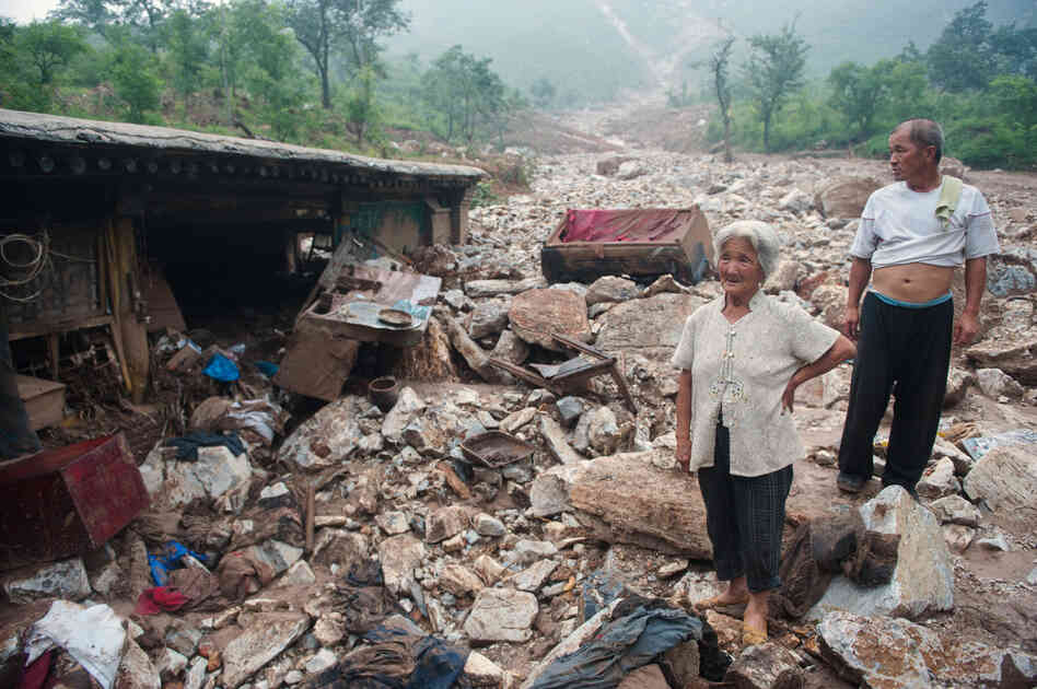 Residents stand by their home in Beijing on Thursday. Many people criticized the government's response to the storms. 