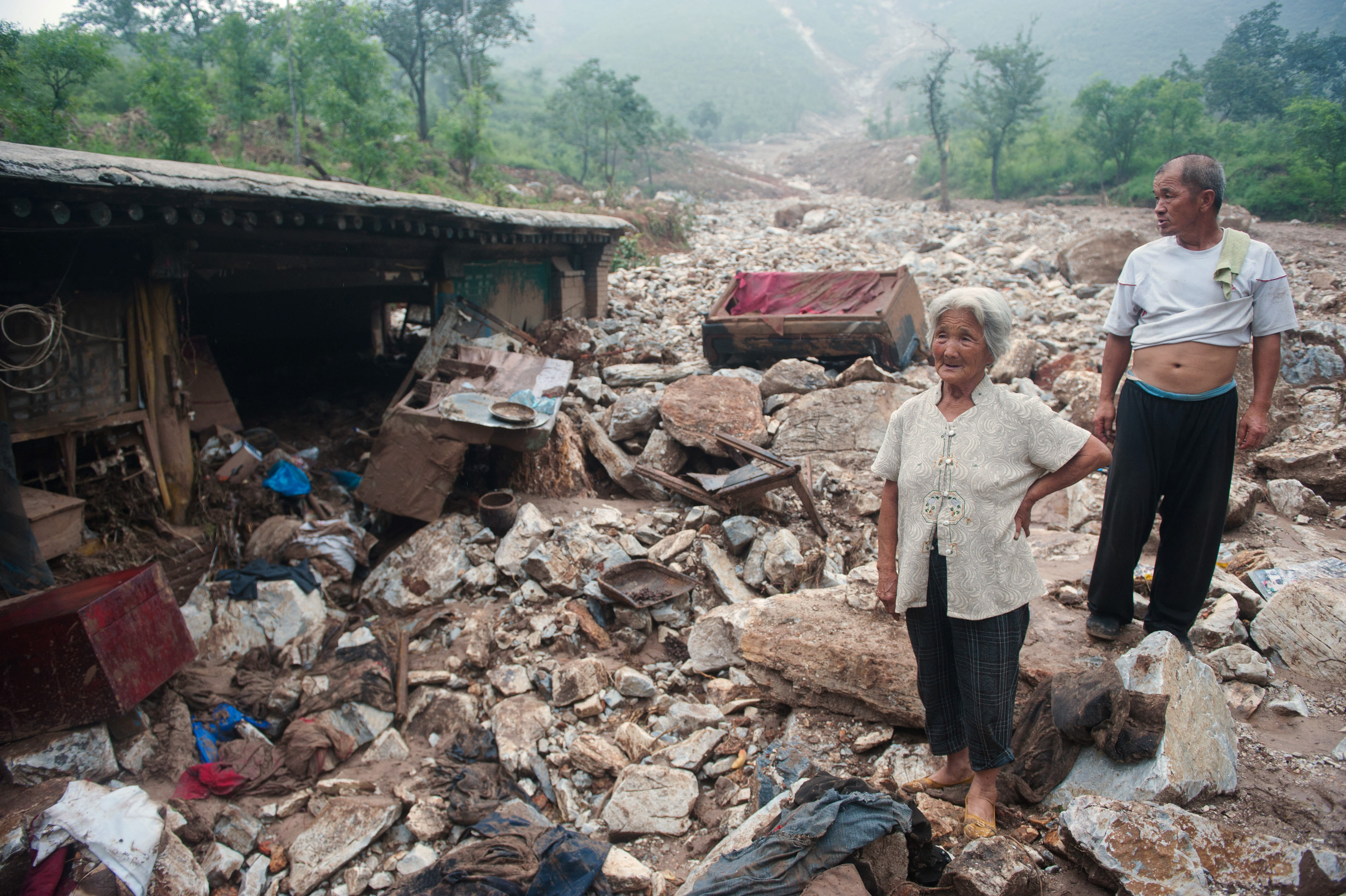 Residents stand by their home in Beijing on Thursday. Many people criticized the government's response to the storms. 