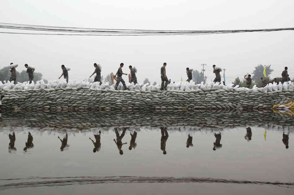 Soldiers place sandbags to block a breaching dyke after heavy rainfalls hit the Fangshan district of Beijing on Wednesday. 