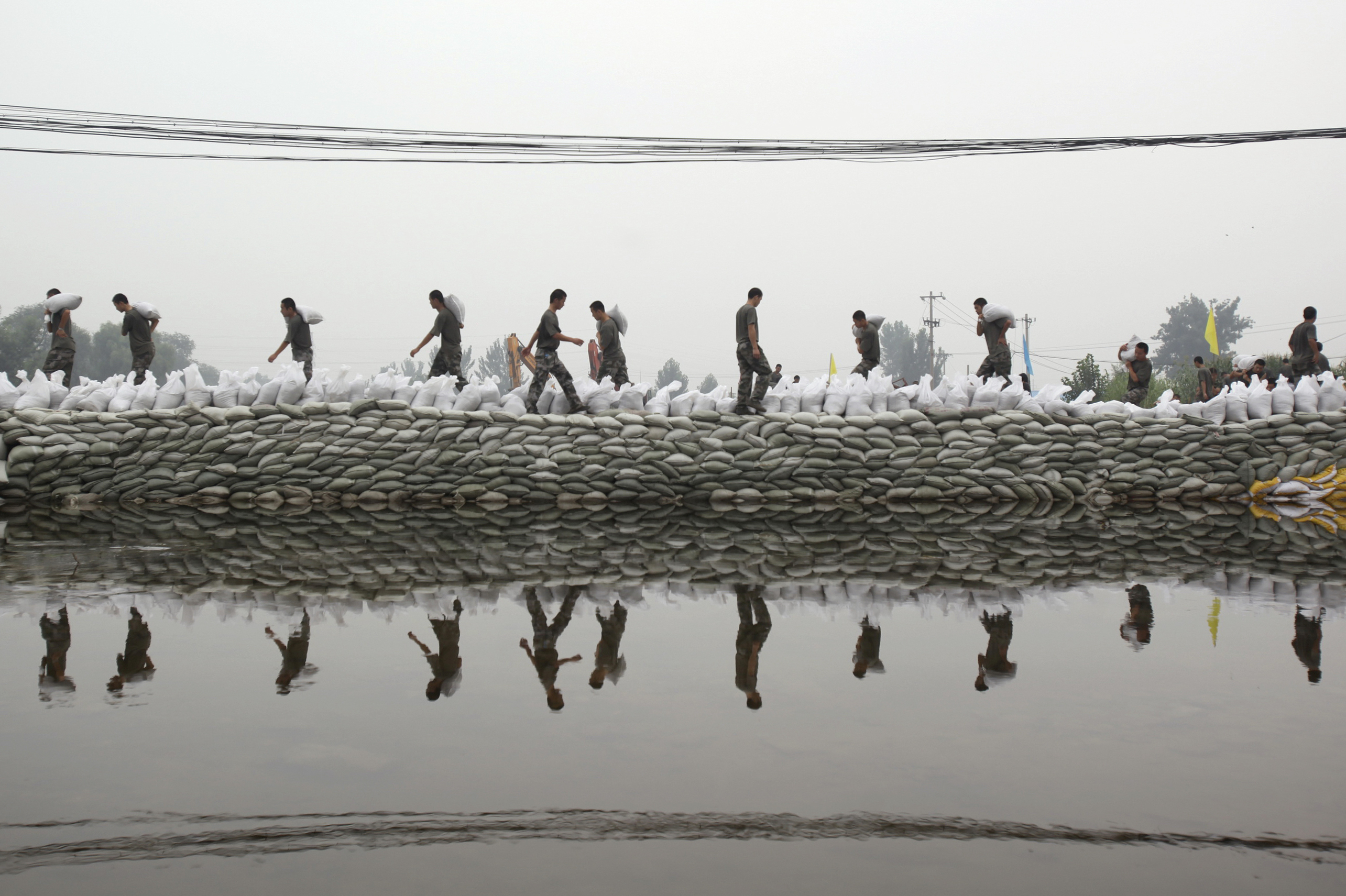 Soldiers place sandbags to block a breaching dyke after heavy rainfalls hit the Fangshan district of Beijing on Wednesday. 