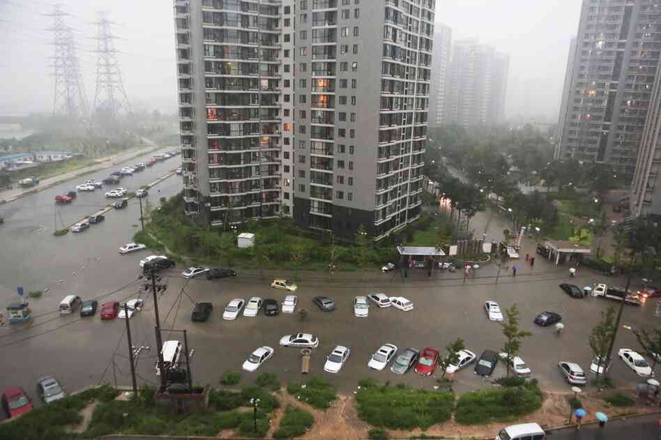 Cars are submerged in floodwaters around a residential block in Beijing.