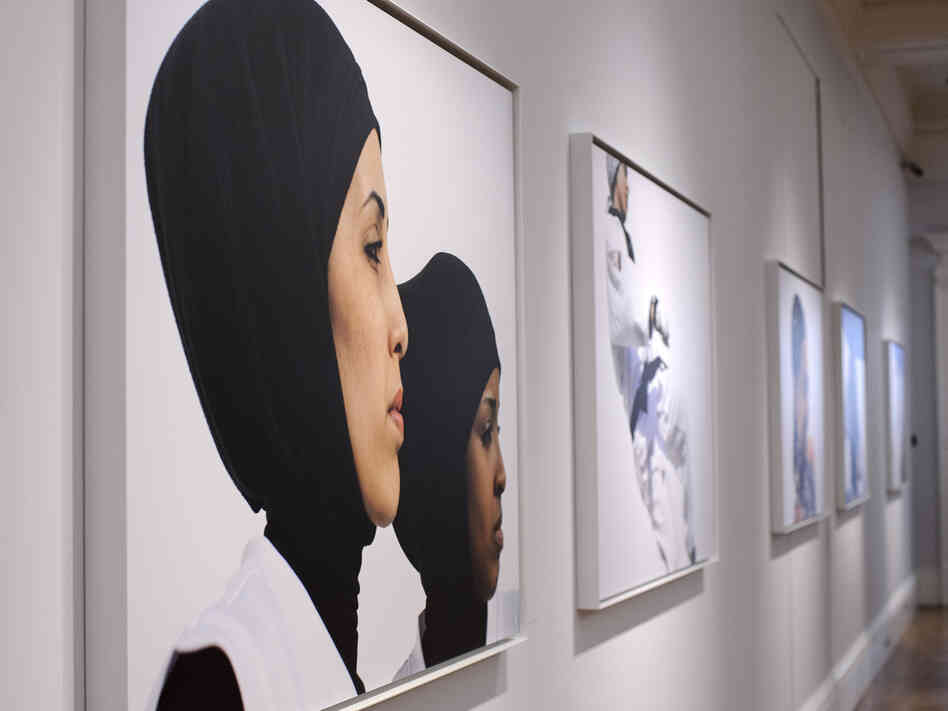 Photos hang at the opening of Hey'Ya Arab Women In Sport by Brigitte and Marian Lacombe at Sotheby's auction house in London.