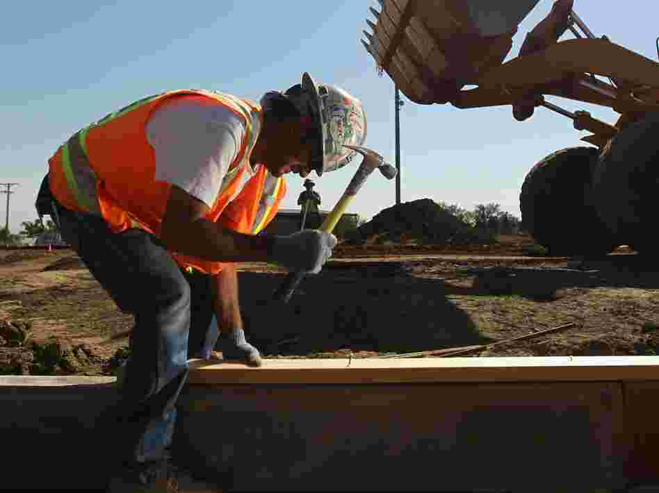 A worker at a Colorado National Guard construction site funded by federal stimulus funds in 2010 in Lakewood, Colo. Economists say the latest gross domestic product report shows the recession was less severe than previously thought. That's because government spending helped prop up the economy. Now, eyes are turning to the Federal Reserve to boost growth.