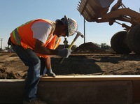 A worker at a Colorado National Guard construction site funded by federal stimulus funds in 2010 in Lakewood, Colo. Economists say the latest gross domestic product report shows the recession was less severe than previously thought. That's because government spending helped prop up the economy. Now, eyes are turning to the Federal Reserve to boost growth.