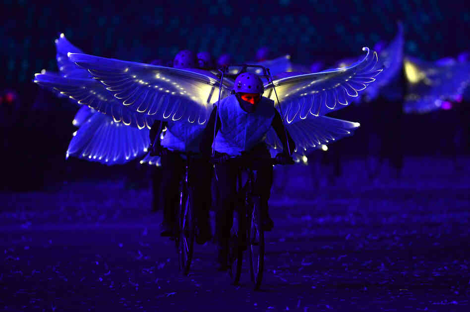 Winged performers ride bicycles during the opening ceremony.