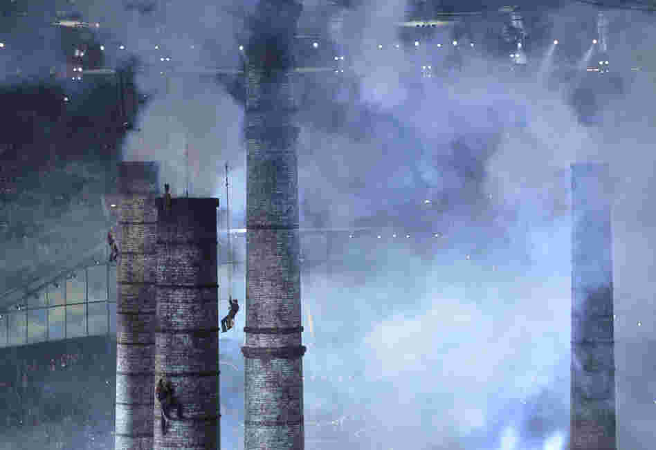 Artists climb chimneys during The Age of Industry scene of the opening ceremony.