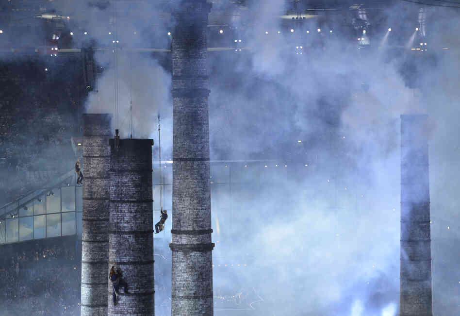 Artists climb chimneys during The Age of Industry scene of the opening ceremony.