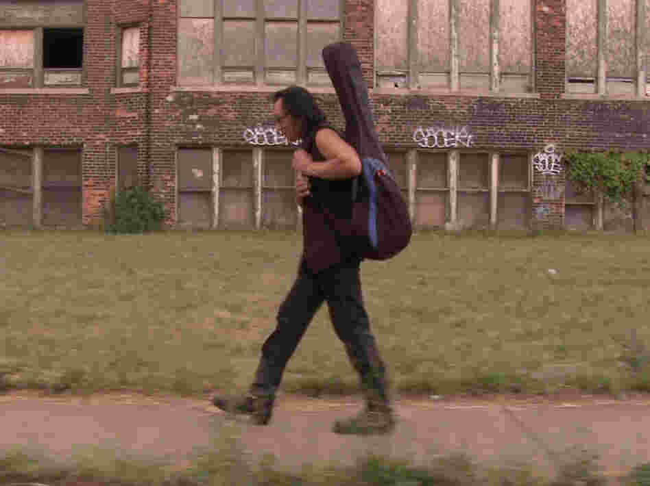 Rodriguez carries his guitar through Detroit, Mich., his hometown.