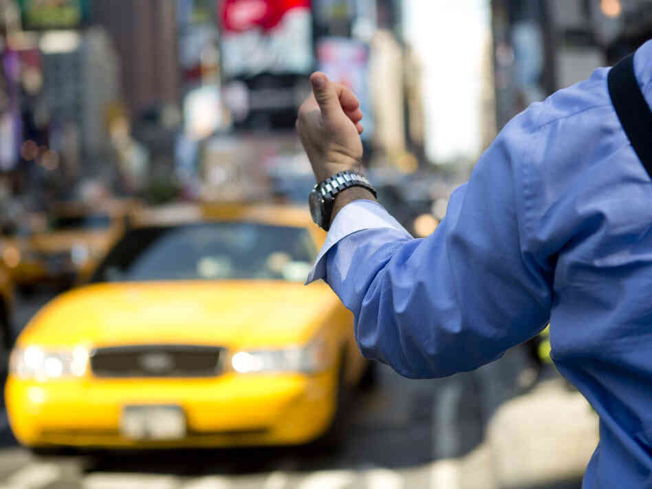 A man hails a cab in Times Square. A man hails a cab in Times Square.