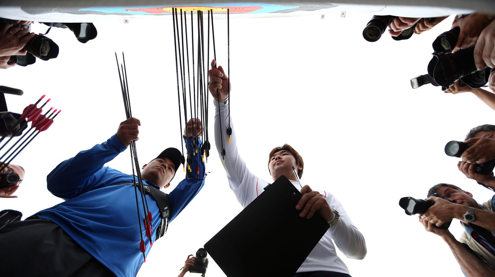 Archer Im Dong-hyun (right) of South Korea inspects his target after breaking the world record during the men's ranking round Friday.