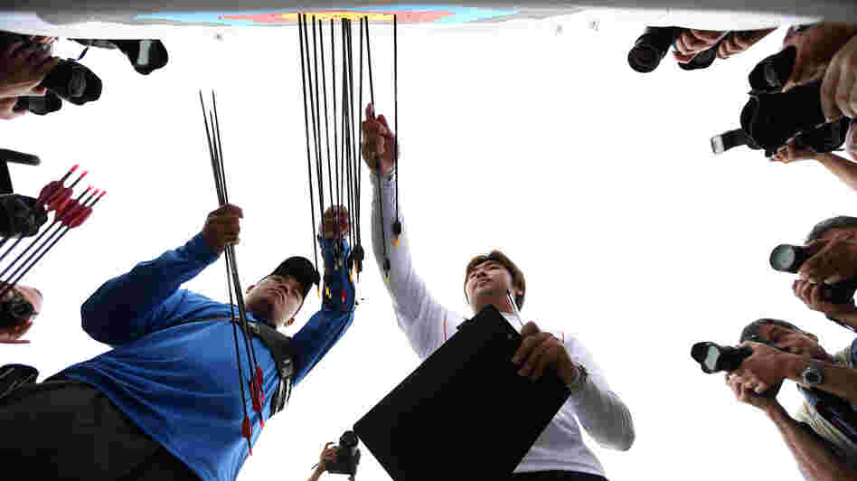 Archer Im Dong-hyun (right) of South Korea inspects his target after breaking the world record during the men's ranking round Friday.