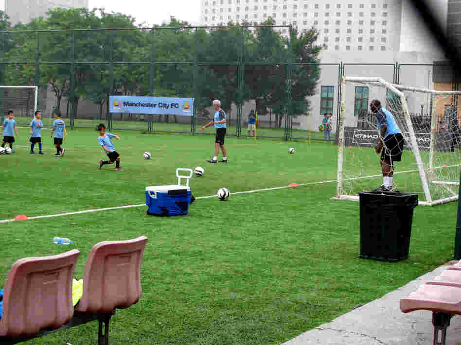 Aspiring soccer stars try to score against former Manchester City goalkeeper Alex Williams in Beijing. Local soccer clinics provide visiting international teams publicity for themselves and their sponsors.