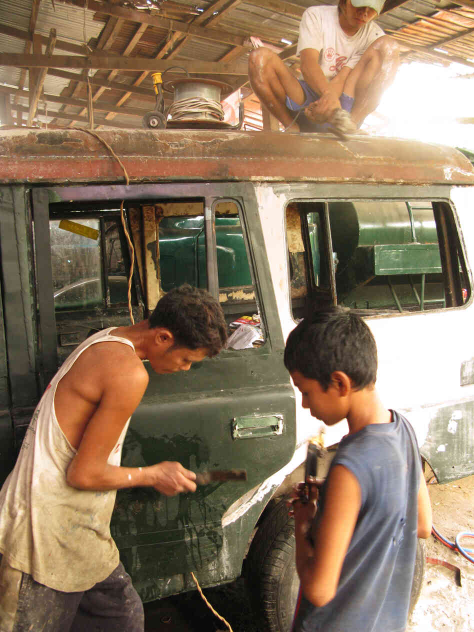 Mechanics at Ohn Myint's car repair shop on the outskirts of Yangon refurbish rusty, decades-old government jeeps.