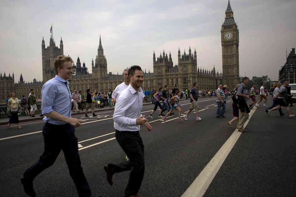 People cross the Westminster bridge to watch the Olympic flame being delivered.