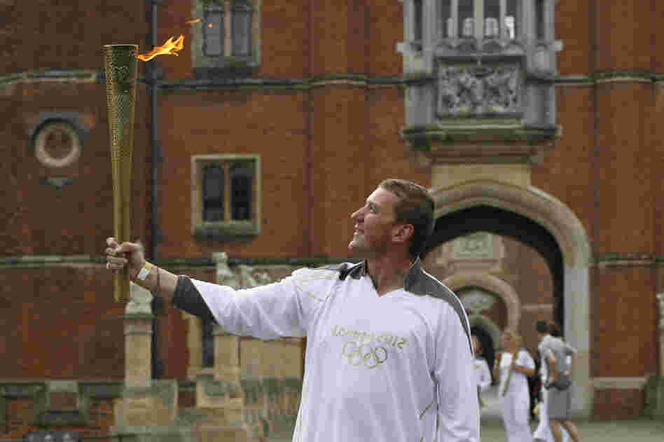 Four-time Olympic rowing gold medalist Matthew Pinsent poses with the torch at the courtyard of Hampton Court Palace in London on the final day of the torch relay.