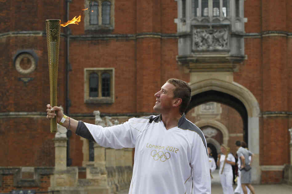 Four-time Olympic rowing gold medalist Matthew Pinsent poses with the torch at the courtyard of Hampton Court Palace in London on the final day of the torch relay.
