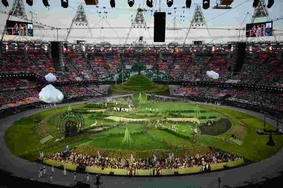 Animals and actors enter the stadium for a British meadow scene.