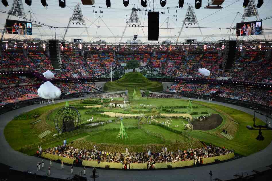 Animals and actors enter the stadium for a British meadow scene.