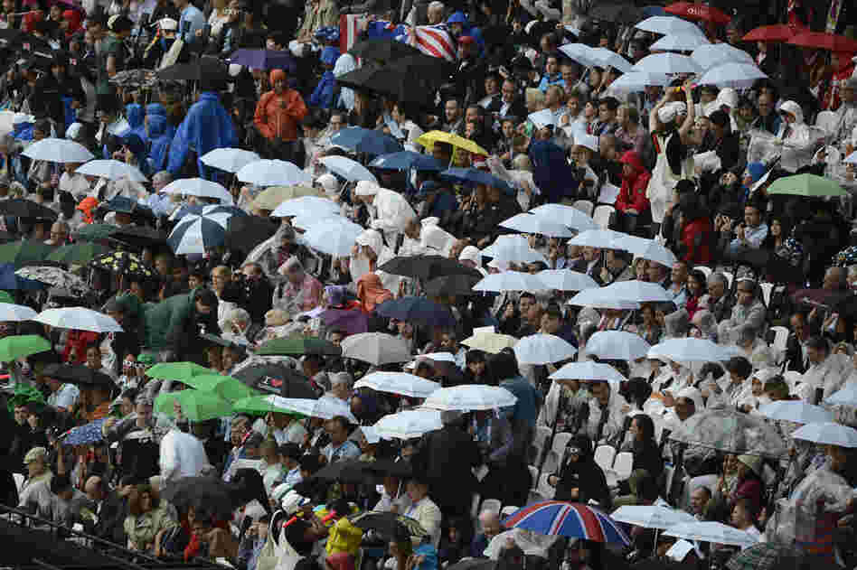 Rain falls on spectators in the Olympic stadium.
