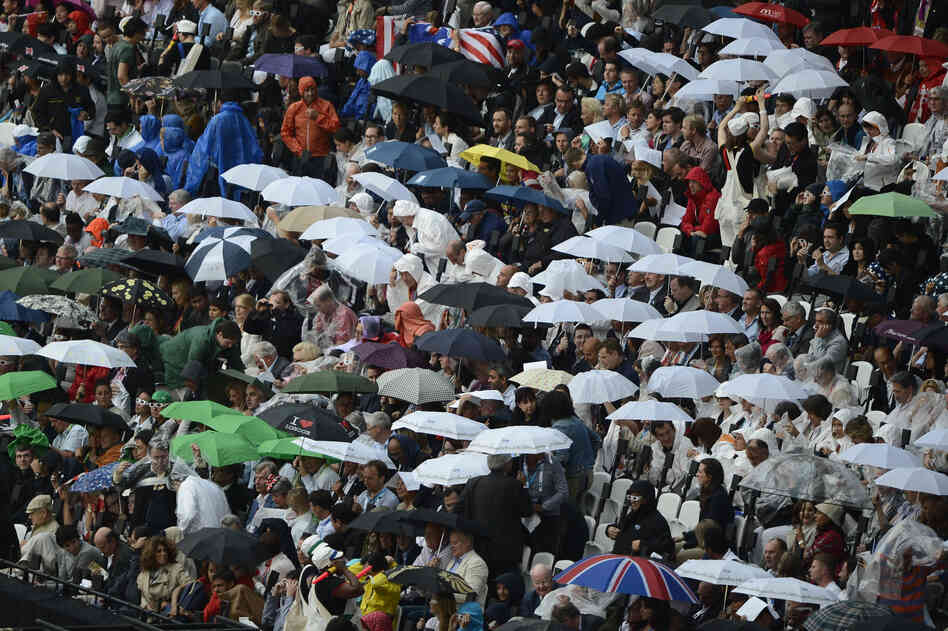 Rain falls on spectators in the Olympic stadium.