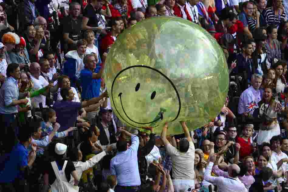 Spectators play with a giant balloon at the Olympic stadium.