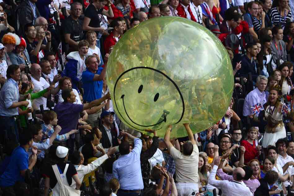 Spectators play with a giant balloon at the Olympic stadium.