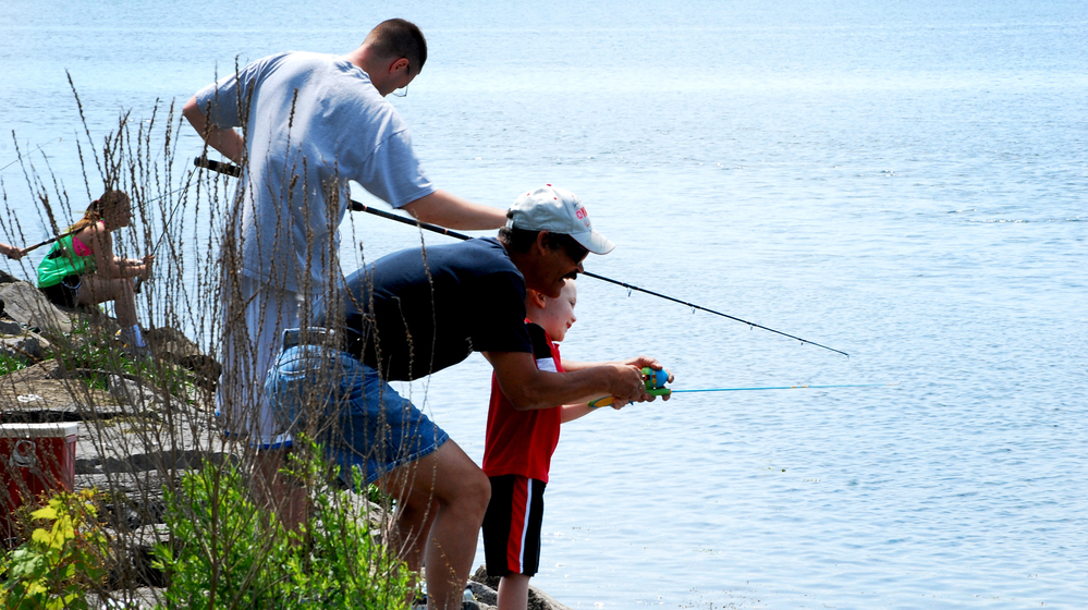 Participants in a fishing derby cast lines from a pier near Onondaga Lake's outflow in Syracuse, N.Y.