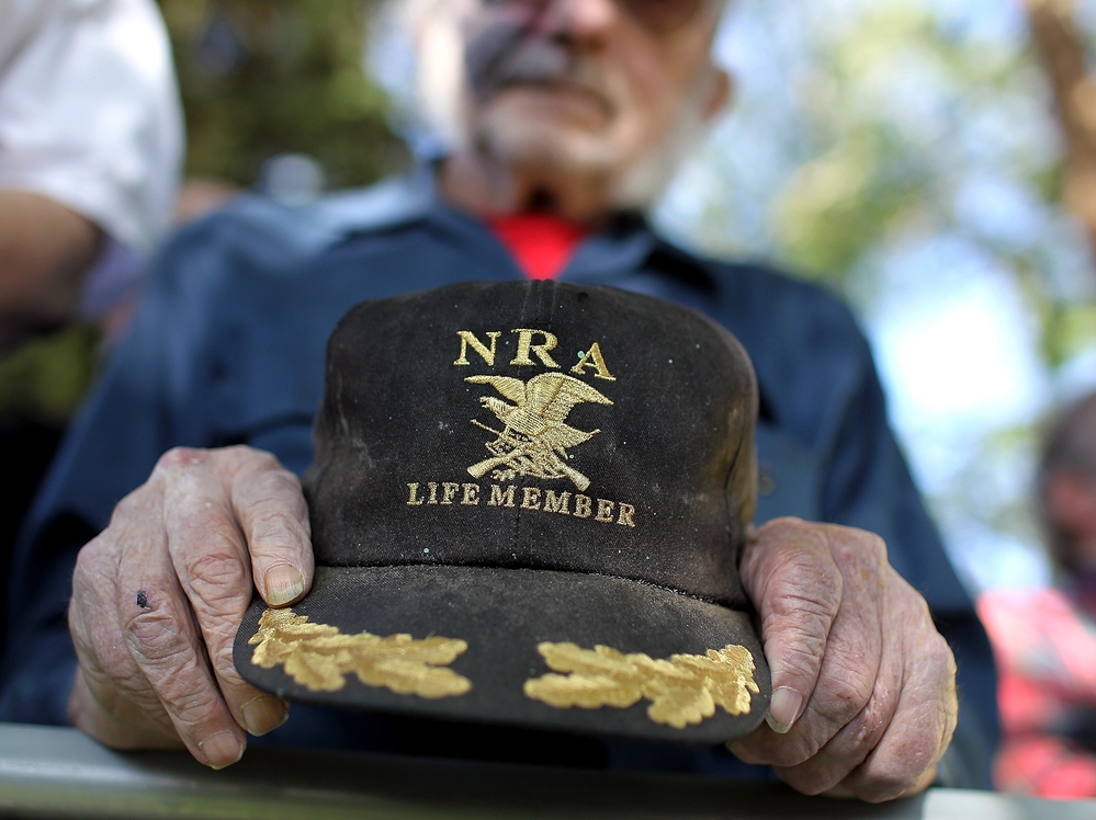 A supporter of Republican presidential candidate Mitt Romney holds an NRA baseball cap during at a campaign rally in Craig, Colo., in May.
