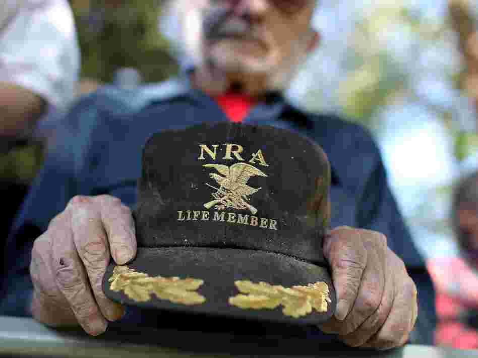 A supporter of Republican presidential candidate Mitt Romney holds an NRA baseball cap during at a campaign rally in Craig, Colo., in May.