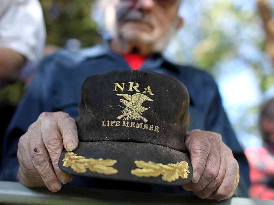 A supporter of Republican presidential candidate Mitt Romney holds an NRA baseball cap during at a campaign rally in Craig, Colo., in May.