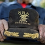 A supporter of Republican presidential candidate Mitt Romney holds an NRA baseball cap during at a campaign rally in Craig, Colo., in May.