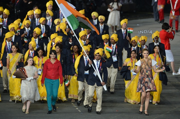 (FILES) A file picture taken on Friday shows a woman (2nd L), reportedly a student from Bangalore and an Olympic volunteer, walking next to India's flagbearer Sushil Kumar.