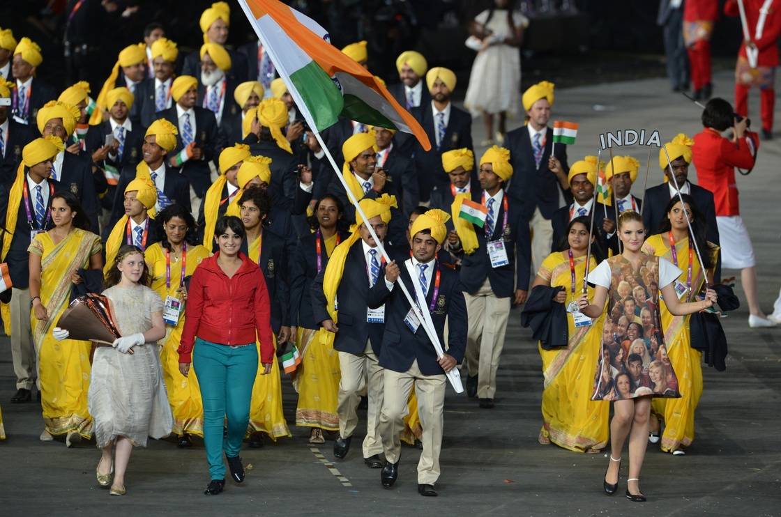 (FILES) A file picture taken on Friday shows a woman (2nd L), reportedly a student from Bangalore and an Olympic volunteer, walking next to India's flagbearer Sushil Kumar.