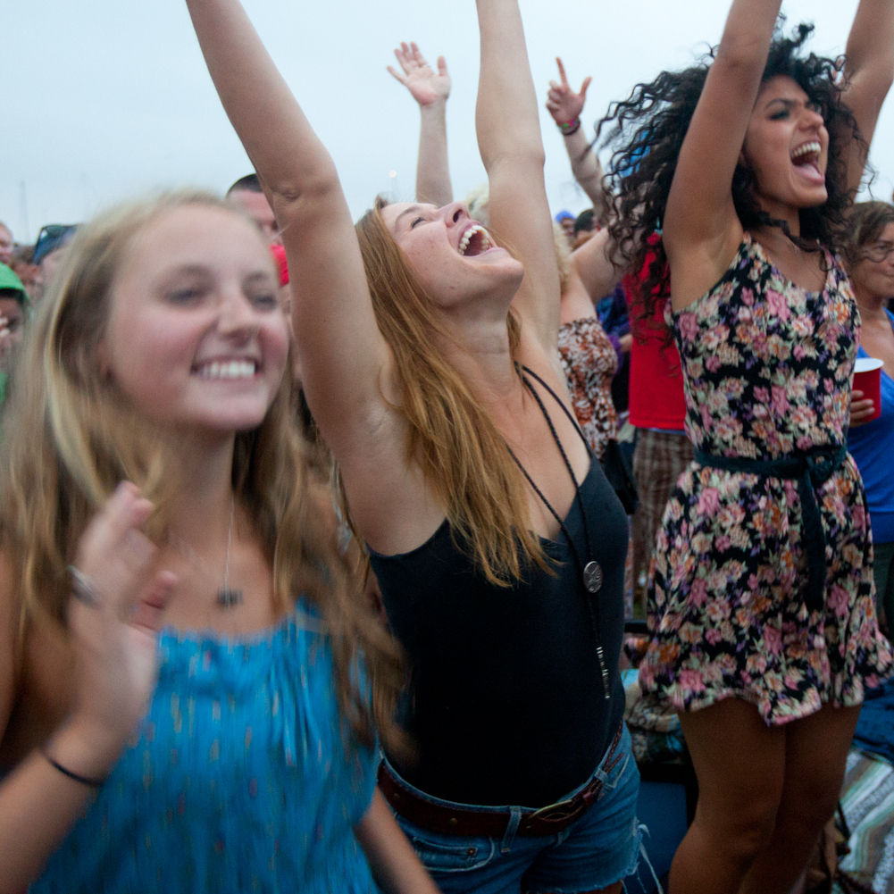 Fans, from left, Jenn Spofford, Chrissy Stewart and Suzanna Kopec, all of Providence, RI cheer for My Morning Jacket as they perform on the Fort Stage at the Newport Folk Festival.