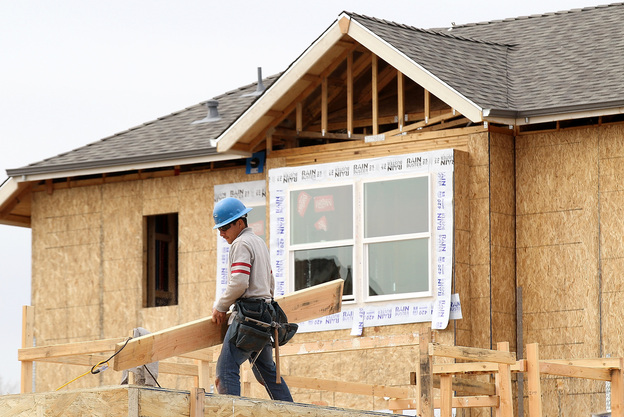 A construction worker carries lumber while working on new homes in San Mateo, Calif., in March. Homebuilding is at its highest level in nearly four years.
