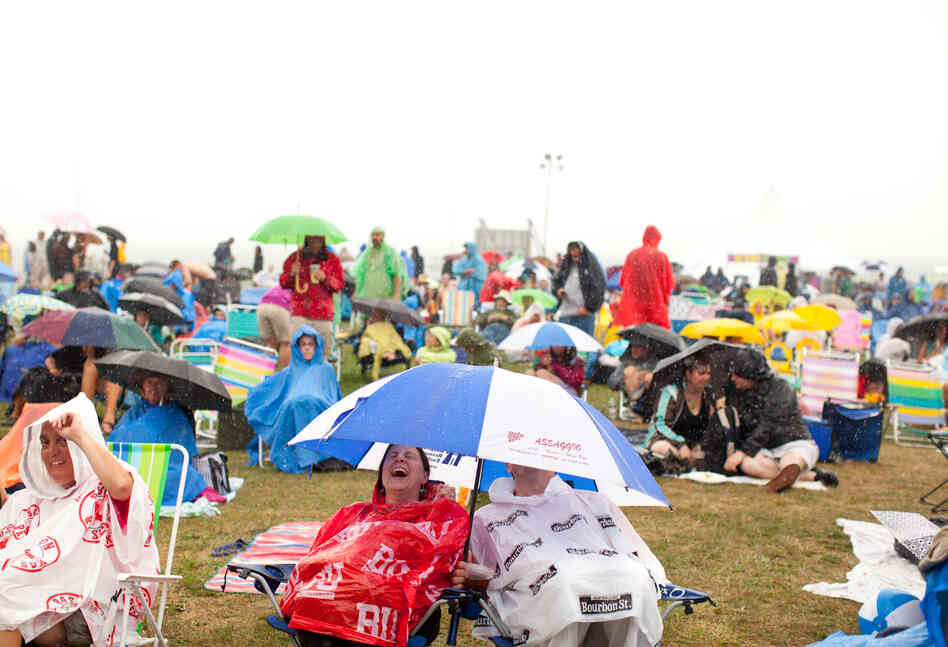 Crowd members tried to stay dry during a downpour on Friday evening.