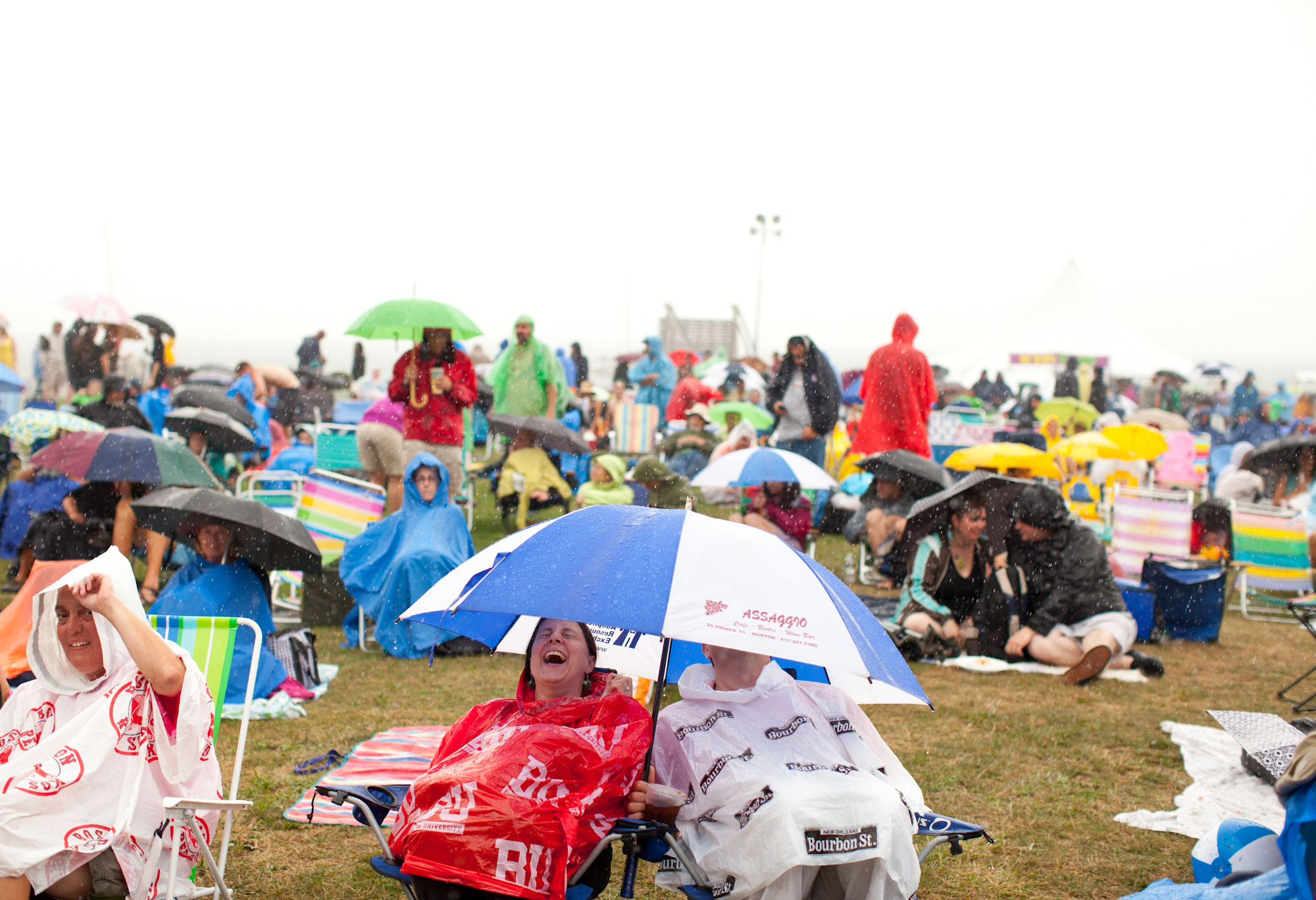 Crowd members tried to stay dry during a downpour on Friday evening.