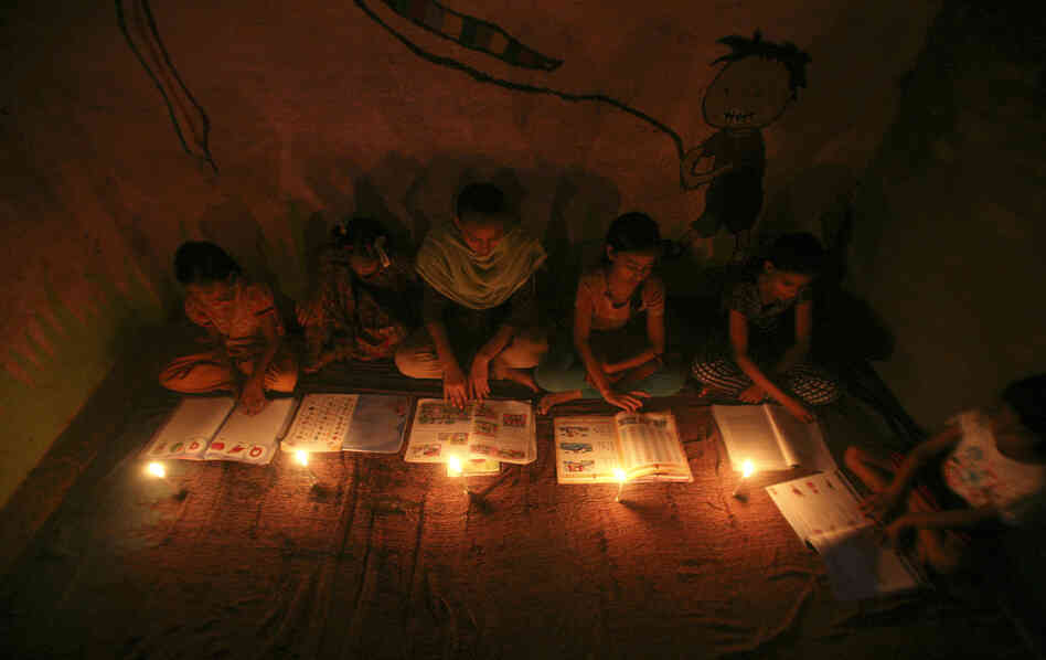 Muslim girls study by candlelight Monday inside a madrasa, or religious school, in Noida, on the outskirts of New Delhi. Three regional power grids collapsed, causing a massive power outage that blacked out more than half of India.